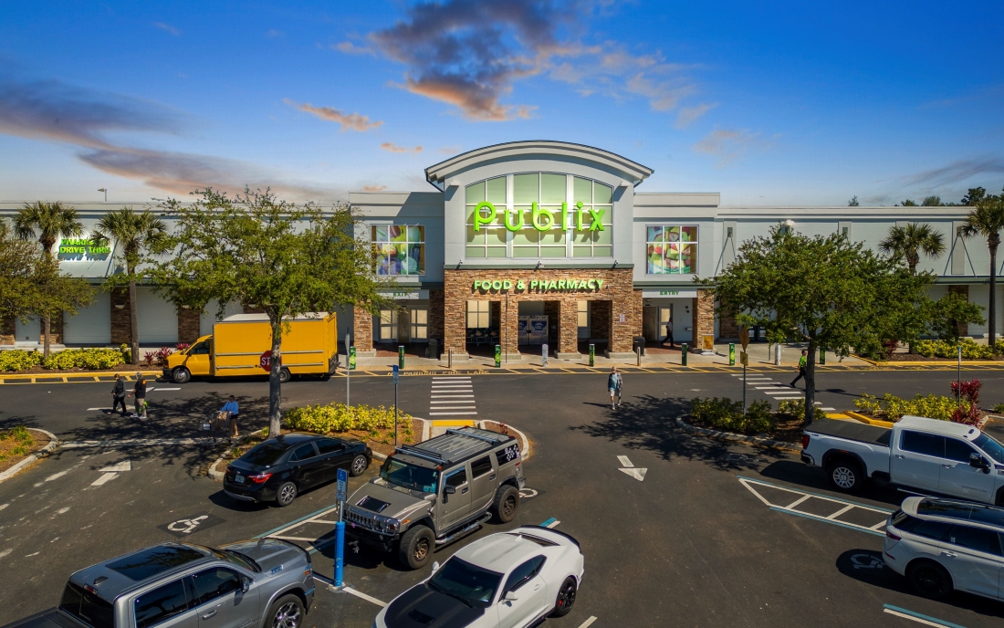 Shoppes of Avalon in Spring Hill, Florida, facade with parked cars in front, showcasing a bustling shopping environment.