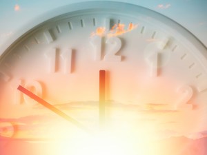 Beautiful cloudy sky and close up of clock. Bright sun. Double exposure. Concept of Daylight Savings Time.