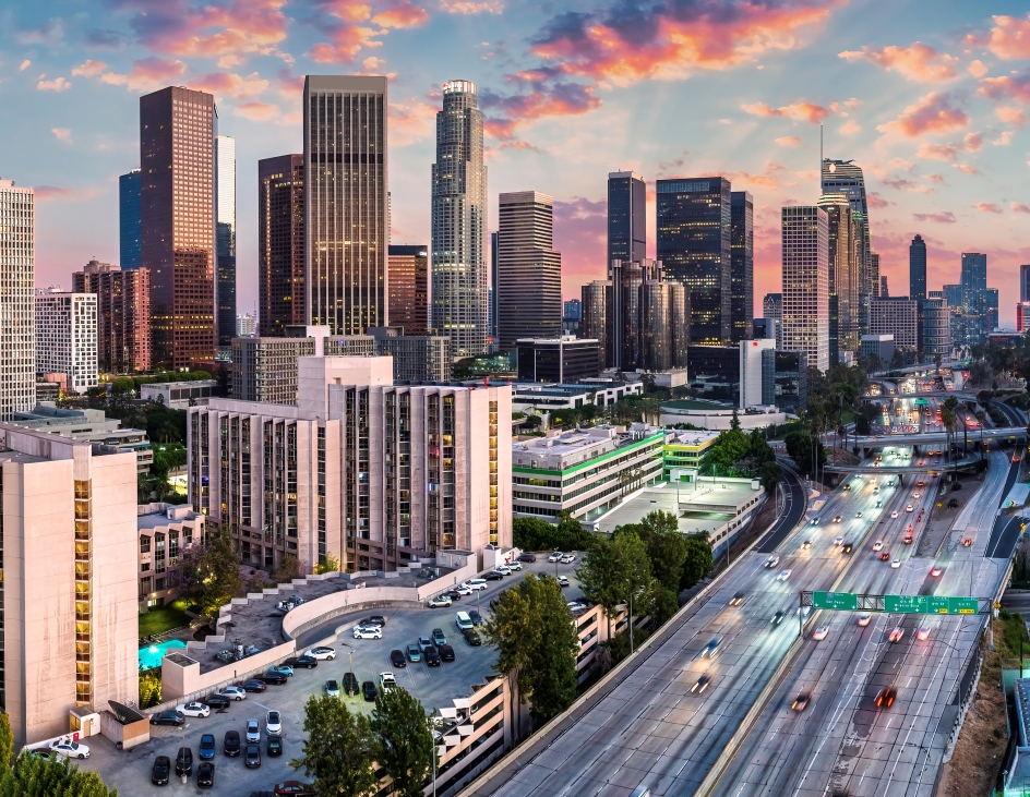 The Los Angeles skyline illuminated by a vibrant sunset, showcasing iconic buildings against a colorful sky.