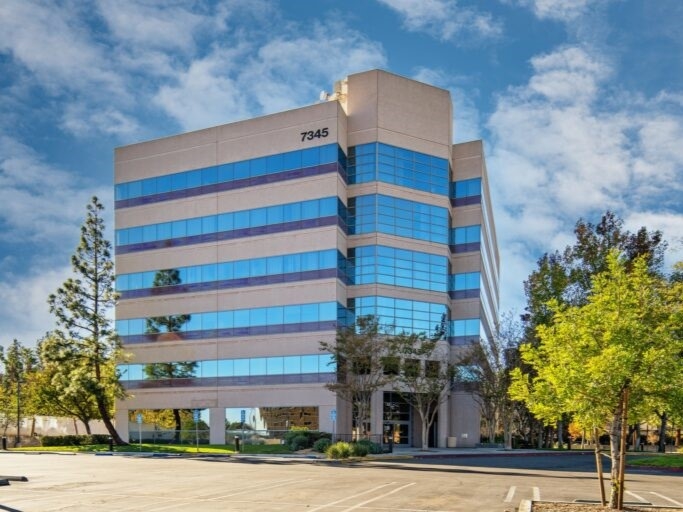 Exterior shot of 7345 Medical Center Drive, a six-story medical office building with glass and concrete façade.