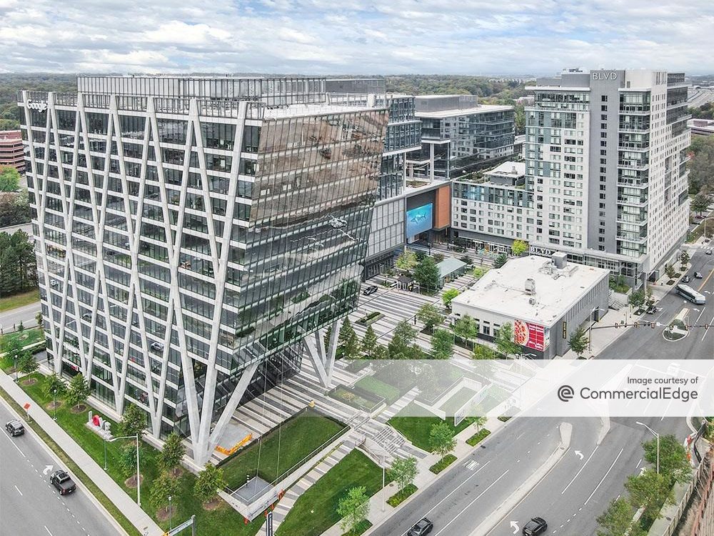 Exterior shot of 1906 Reston Metro Plaza, a 15-story, 150,000-square-foot office building rising above Reston Metro Plaza. The property is part of a 90-acre mixed-use megadevelopment in Reston, Va.