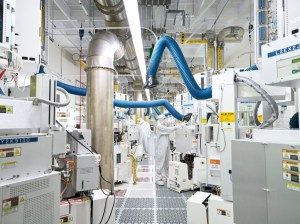 A picture of two employees working in a semiconductor wafer fabrication plant.