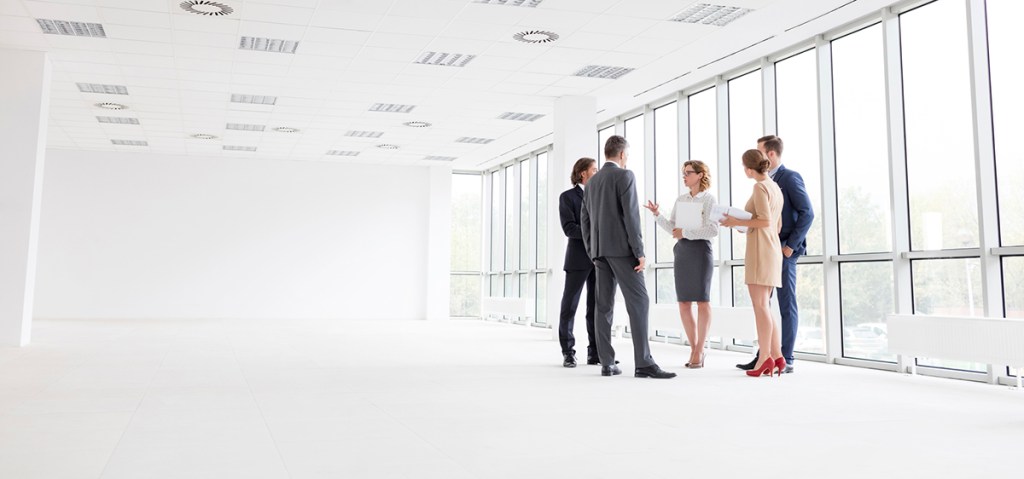 Business colleagues standing while discussing at new office