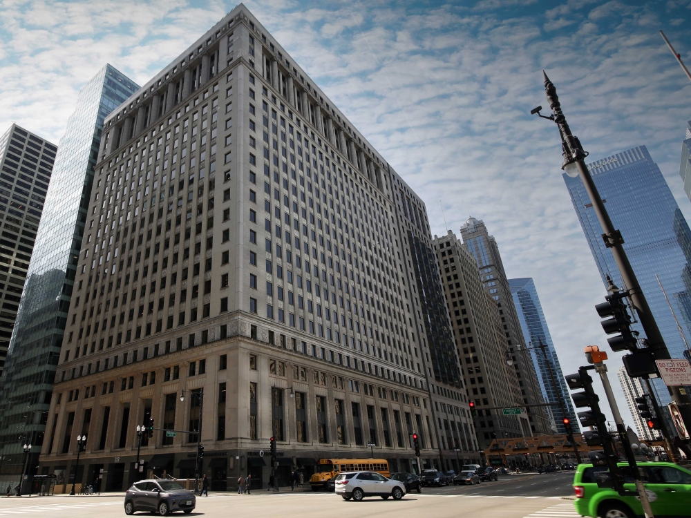 Exterior shot of 222 N. LaSalle St., a 26-story building with beige concrete façade. The building is surrounded by other office towers.