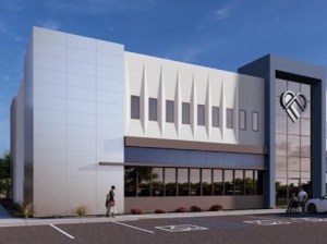 Exterior rendering of one of the facilities at Terraza Medical Village. The building rises two stories and has white, gray and brown exterior, as well as a heart logo on it.